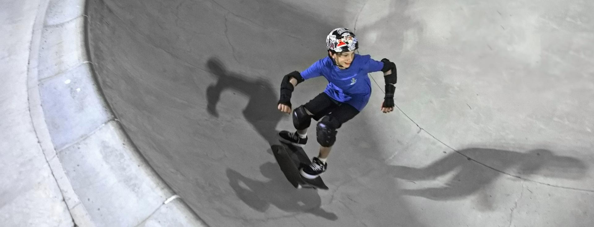 Ein Jugendlicher fährt auf einem Skateboard in einem Skate Park.