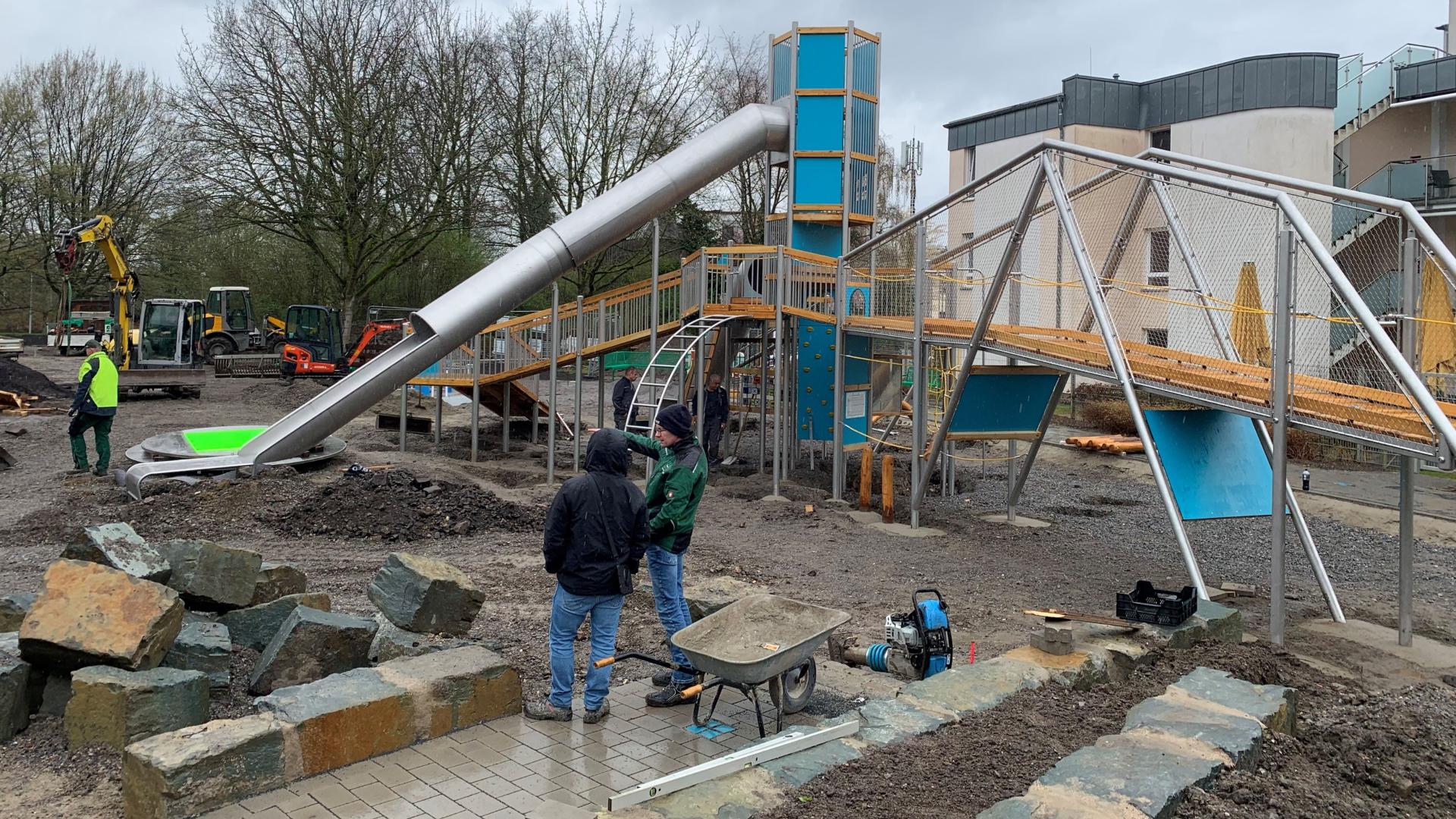 Das Foto zeigt den Spielplatz am Schloßberg während der Bauphase, das Kletterelement mit Rutsche wird aufgebaut
