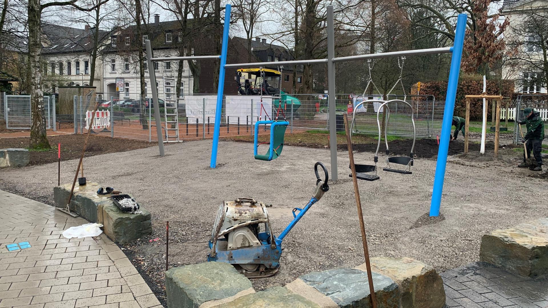 Das Foto zeigt den Spielplatz am Schloßberg während der Bauphase, das Schaukelelement wird aufgebaut