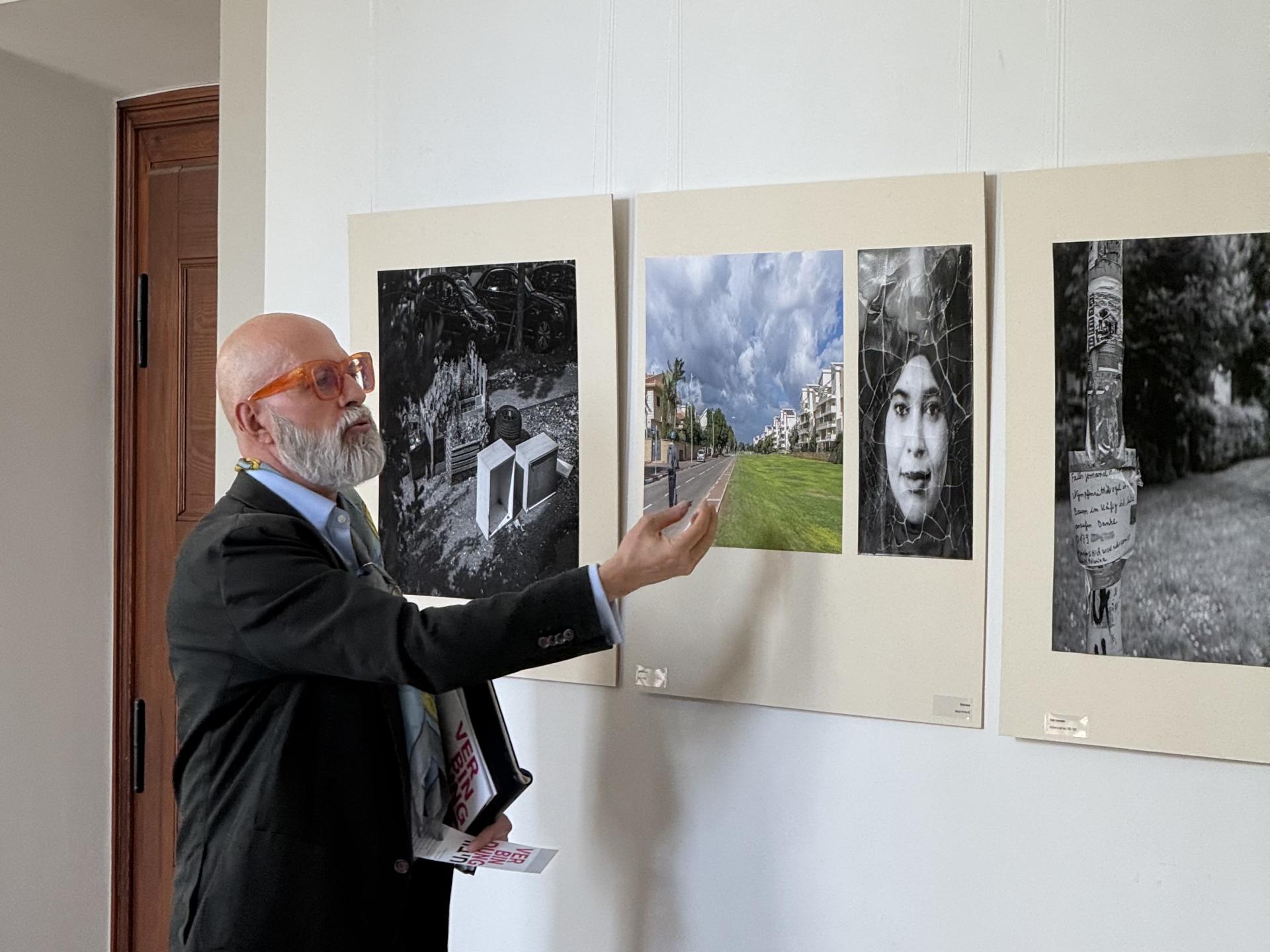 Frank Schablewski führt die Besucherinnen und Besucher im Rahmen der Ausstellungseröffnung von „Verbindung – חיבור“ in die Fotografien ein und gibt dabei Einblicke in die Arbeiten der beteiligten Künstlerinnen und Künstler aus Mülheim und Kfar Saba.