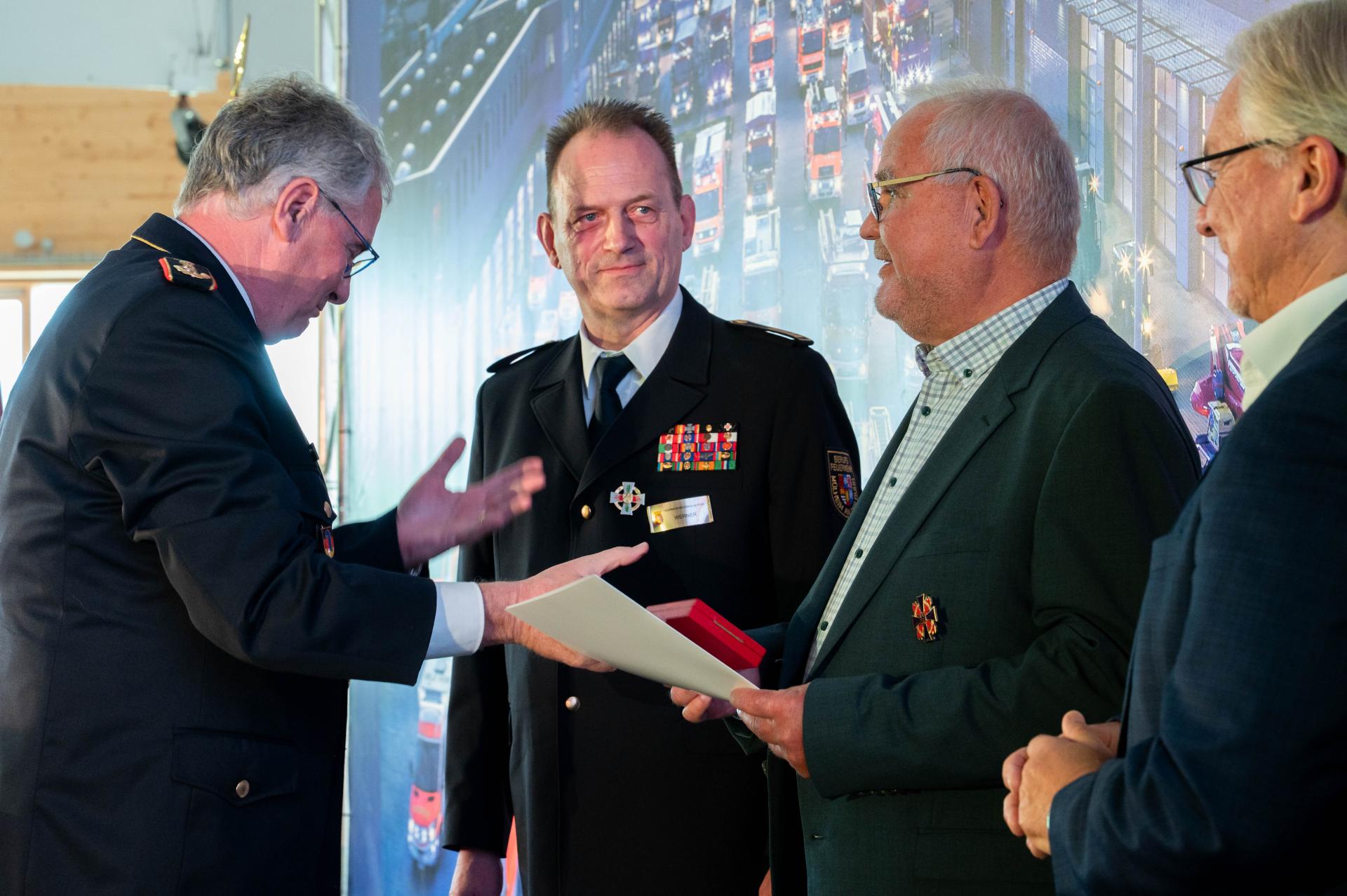 Karl-Heinz Banse überreicht Burkhard Klein eine Urkunde und ein Ehrenzeichen. Sven Werner und Marc Buchholz begleiten die Ehrung.
