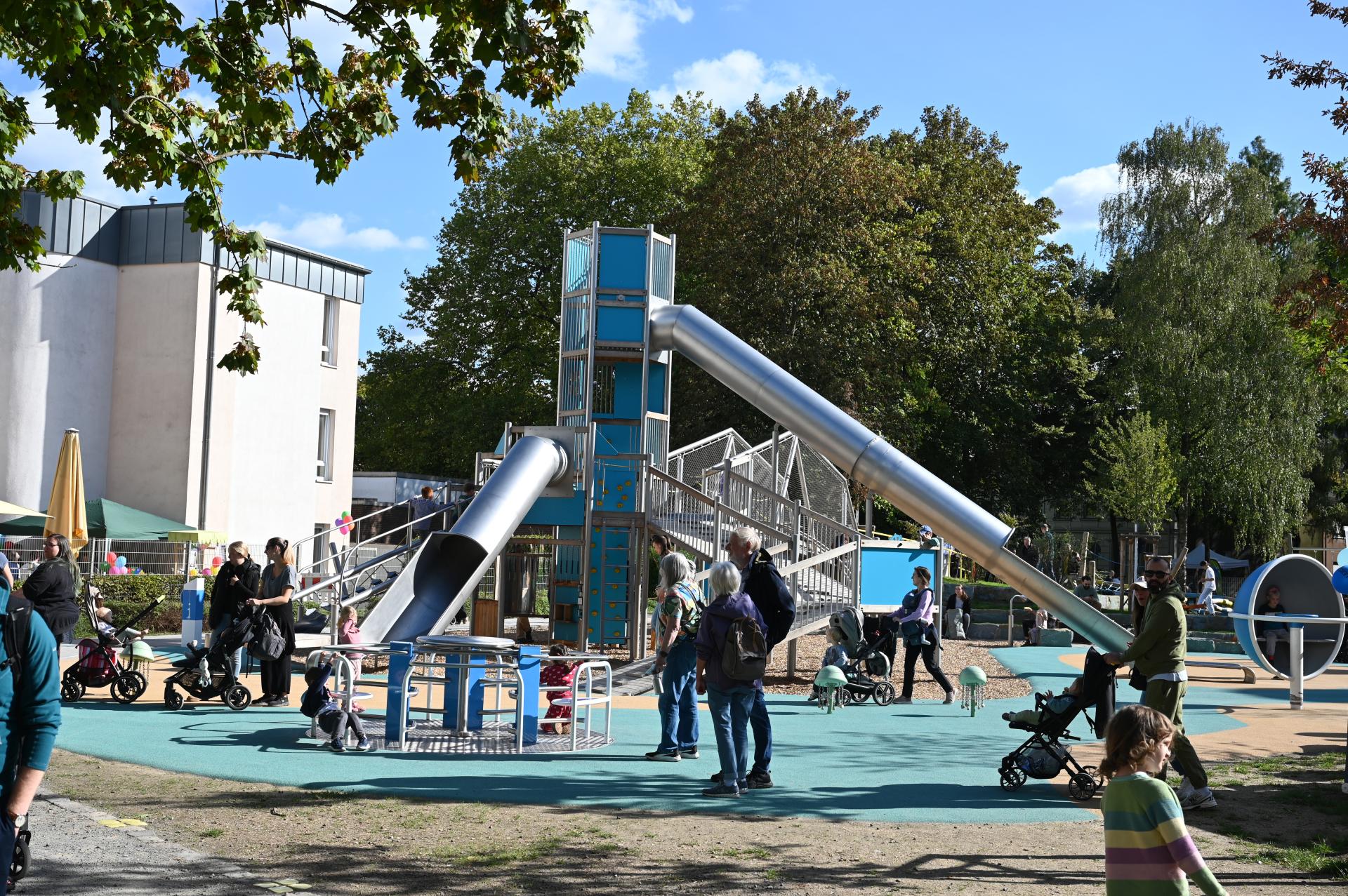 Das Großspielgerät mit Rutsche und vielen Gästen auf dem Inklusiven Spielplatz bei der offiziellen Eröffnung.