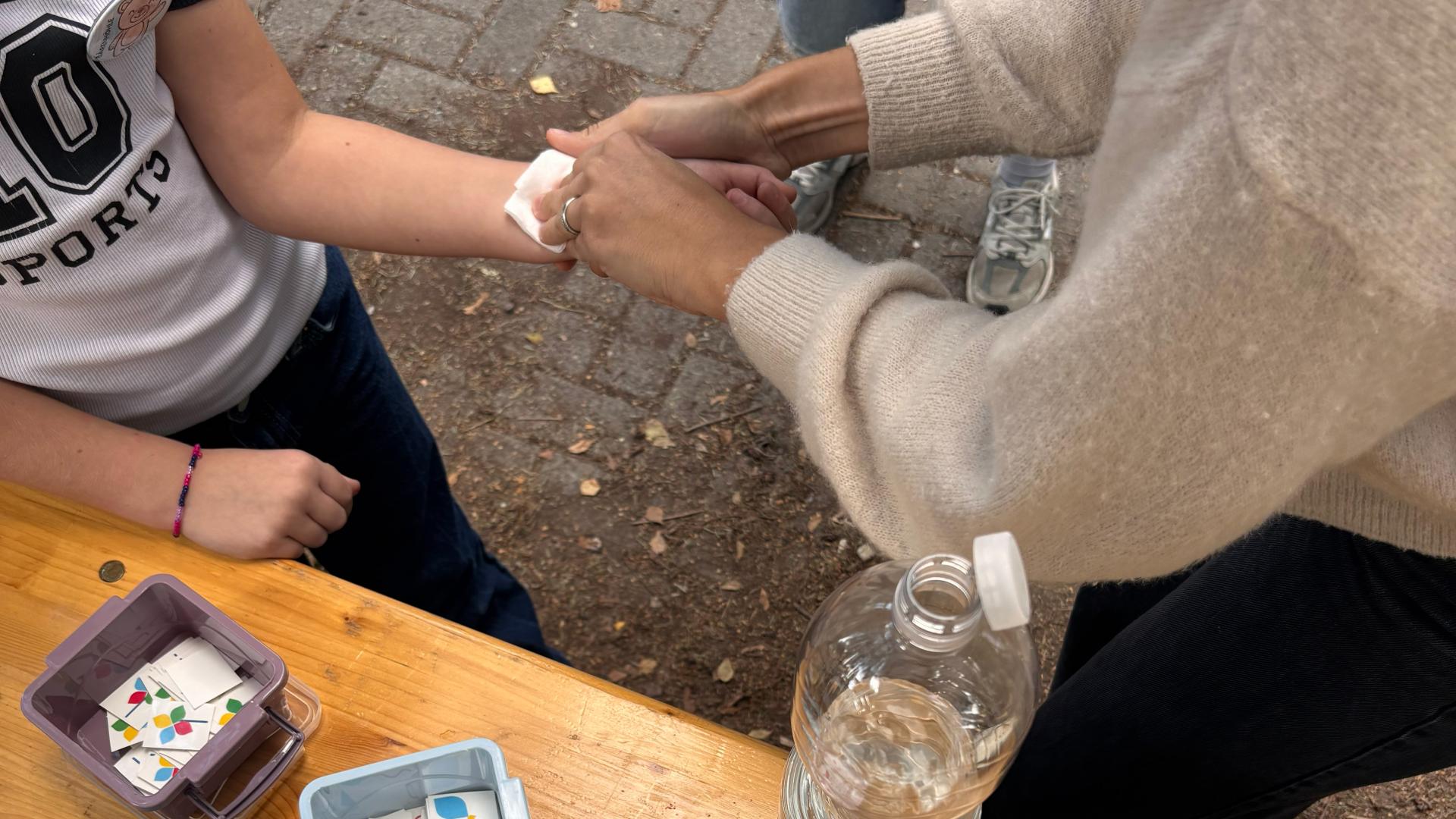 das Foto zeigt, wie eine Frau einem Kind ein Klebetattoo aufklebt